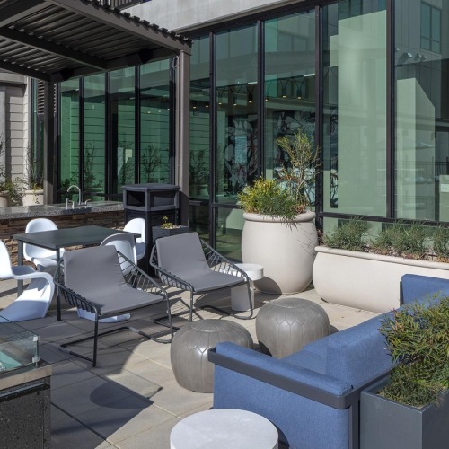 a patio with chairs and plants