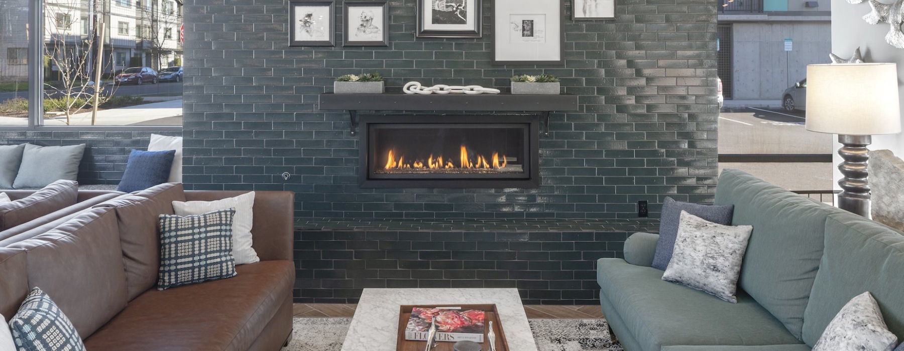 Indoor fireplace with comfortable seating in community space at Oak Street Lofts apartments in Washington County